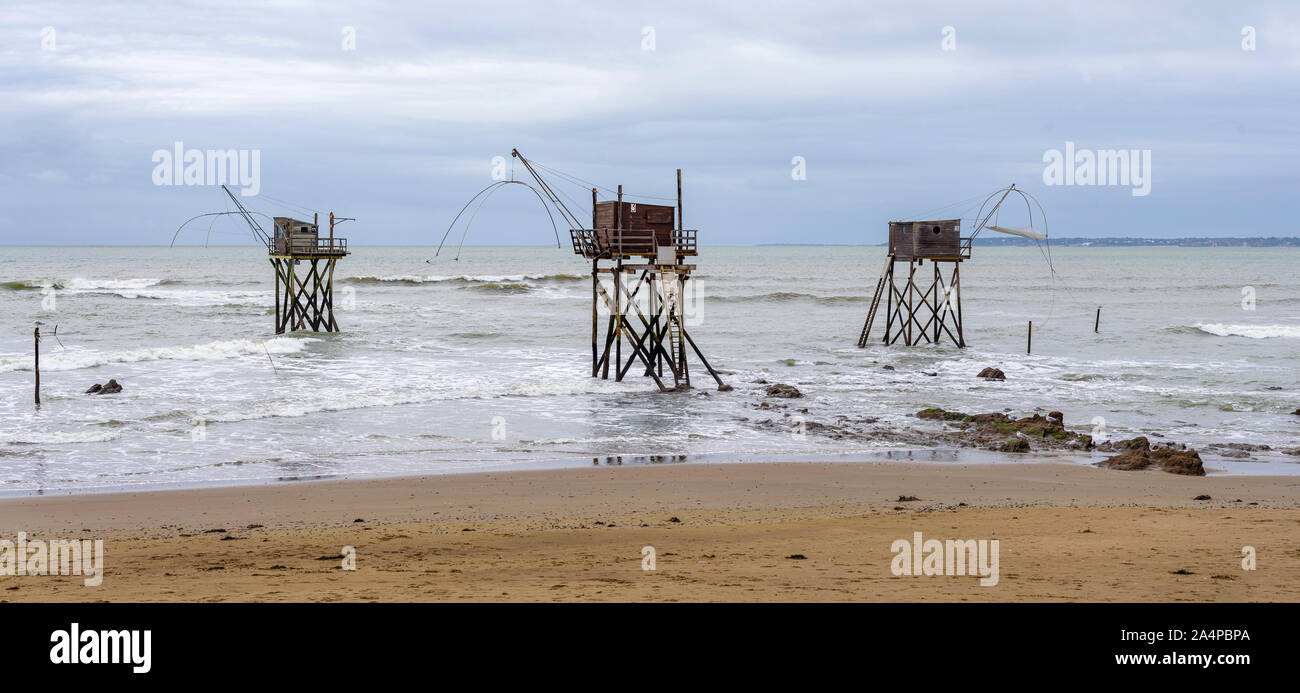 Vista panoramica di tre carrelet tipiche baite di pesca su una spiaggia a Saint-Michel-Chef-Chef, dipartimento Loire-Atlantique, Francia occidentale. Foto Stock