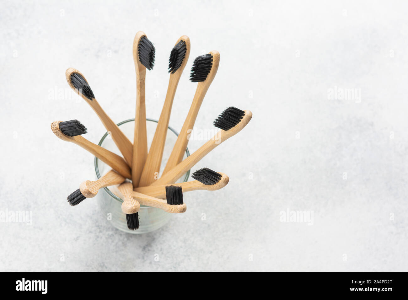 Rifiuti Zero eco-friendly spazzolini da denti di bambù in vetro sul tavolo bianco, il fuoco selettivo Foto Stock