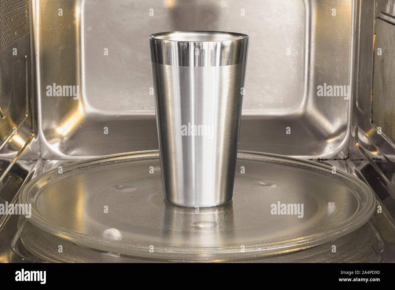 Coppa in alluminio all'interno del forno a microonde. Il riscaldamento  della tazza di alluminio in un forno a microonde. Non è sicuro l'azione  Foto stock - Alamy