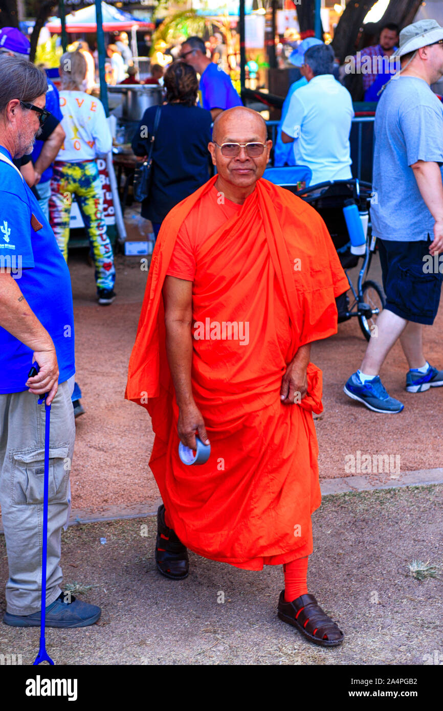 Un monaco tibetano con indosso la sua veste arancione e arancione calze con sandles al Tucson incontrare te Folk Festival Foto Stock