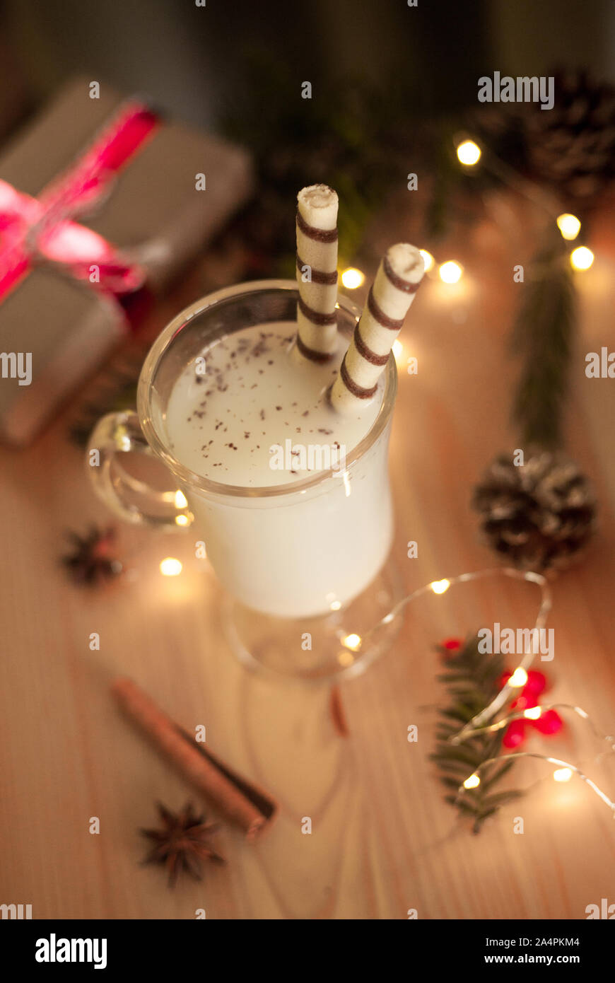 Tradizionale Natale bere zabaione con canditi e spezie. Vista dall'alto. Messa a fuoco selettiva. Sfocate luci fairy. Foto Stock