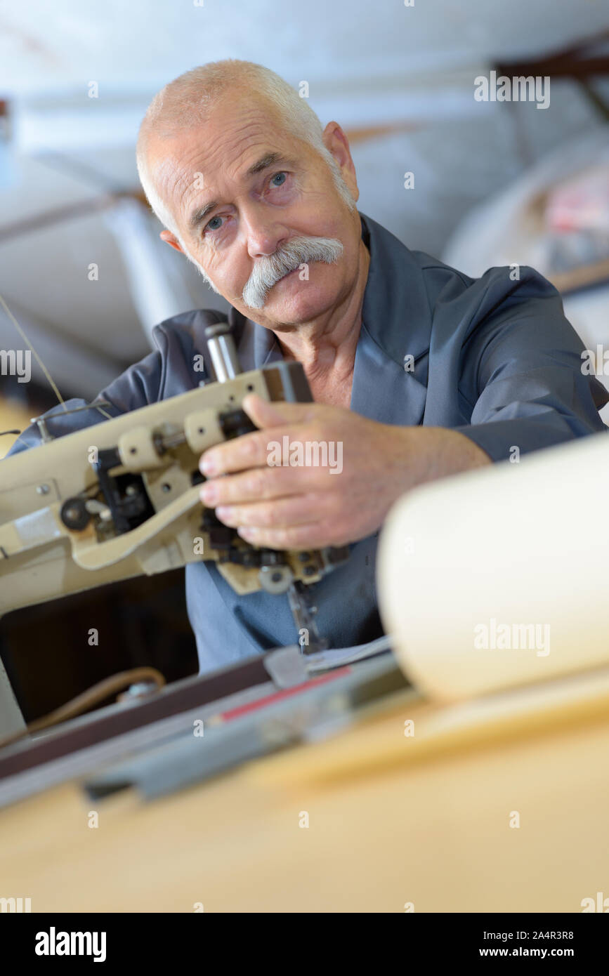 Operaio di fabbrica di cucitura del materiale di copertura Foto Stock