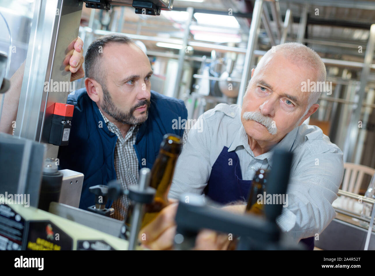 Birreria maschio i lavoratori a versare birra dal serbatoio Foto Stock