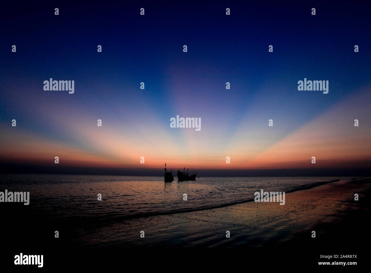 Due pescherecci ancorati al tramonto sulla spiaggia Kuakata. Questo è uno dei rari luoghi naturali che offre una vista completa del sorgere e tramonto sulla baia del Bengala. Una popolare destinazione turistica, si trova a circa 320 chilometri a sud di Dacca, capitale del Bangladesh. Patuakhali, Bangladesh. Novembre 11, 2010. Foto Stock