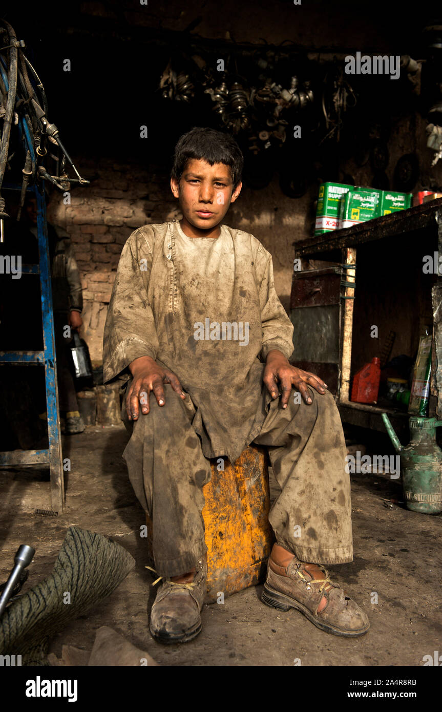 Un ragazzo afghano in un workshop di automobile, nel nord-ovest della città di Herat, Afghanistan. Il 6 maggio 2009. I ragazzi che si uniscono come 'shagrid' (allievo) all'sweatshops guadagna circa 300 Afghana (6 U.S. Di dollari) a settimana. Foto Stock