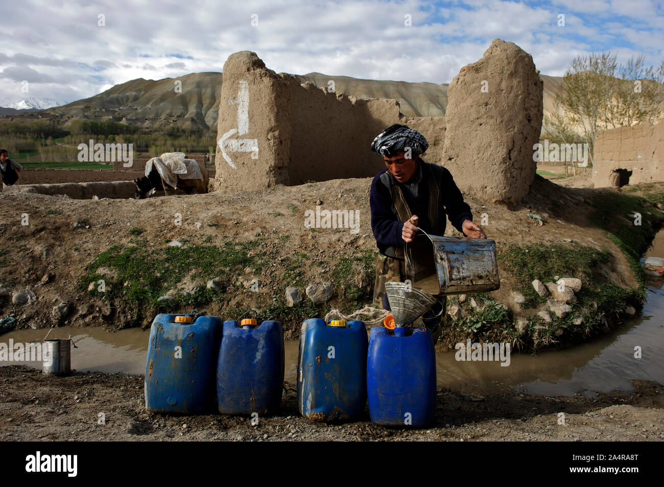 Un uomo raccoglie acqua da un flusso, nella periferia della città di Bamyan, nella provincia di Mazar-i-Sharif, Afghanistan. La gente deve camminare per chilometri per raggiungere i flussi per ottenere acqua per soddisfare il loro fabbisogno interno. Il 11 maggio 2009. Foto Stock