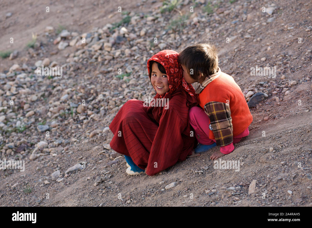 Due ragazze afgane scherzosamente scorrere su una collina nel villaggio di rag-e-Shad, nella periferia della città di Bamyan, nella provincia di Mazar-i-Sharif, Afghanistan. Il 11 maggio 2011. Foto Stock