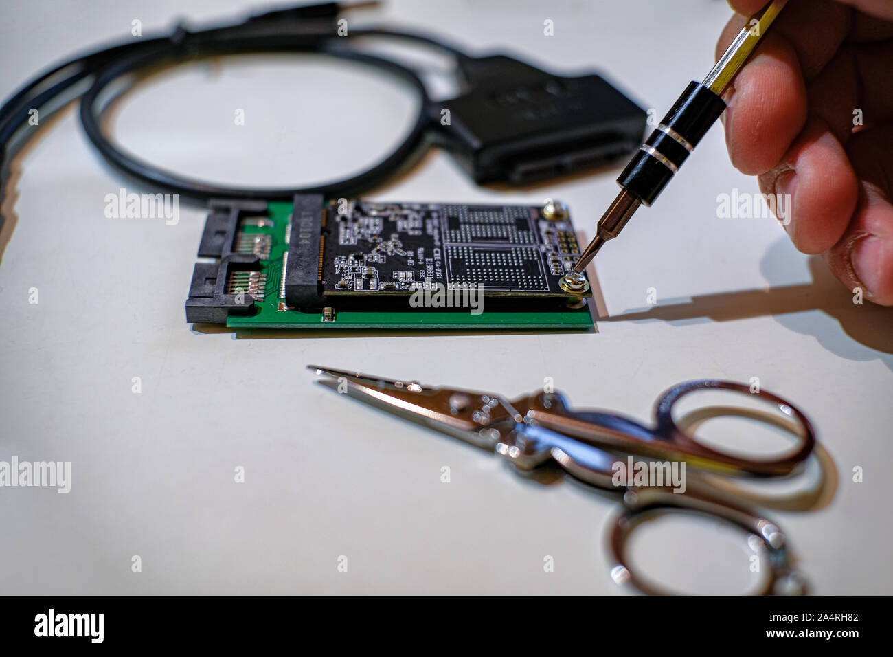 Le mani umane lavorando su chipset ssd componenti di computer con un cacciavite Foto Stock