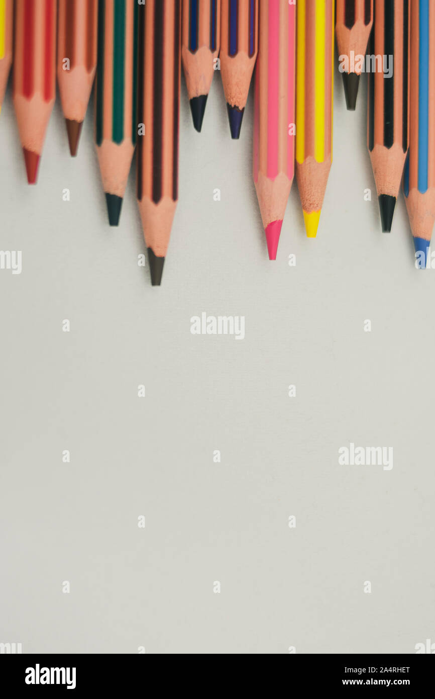 Sharp matite colorate non sono allineati orizzontalmente e collocato sulla sommità verticalmente su sfondo bianco Foto Stock