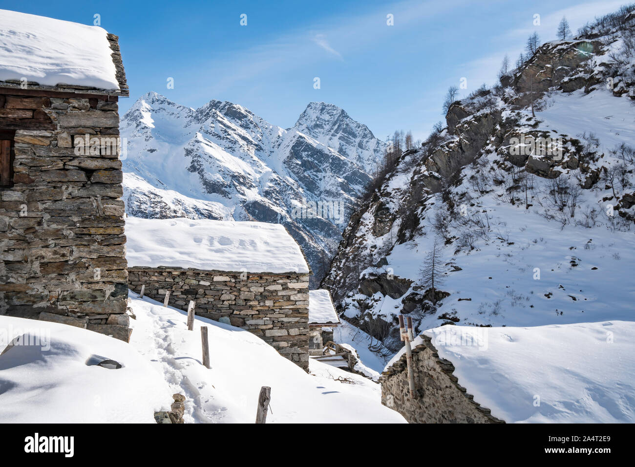 Paesaggio alpino con le case di pietra e montagne innevate. Foto Stock