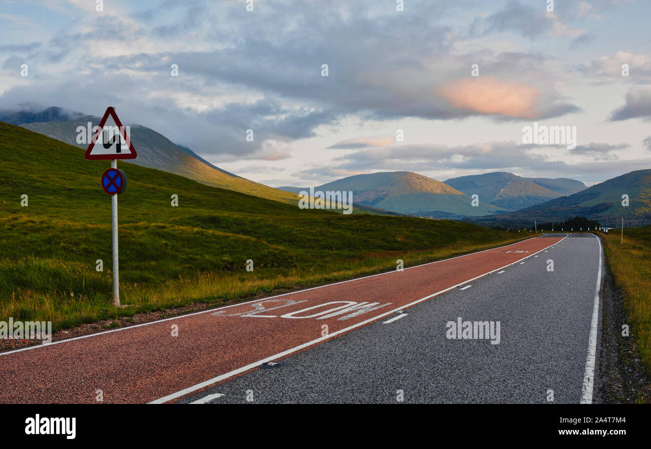 Strada tortuosa segno sulla strada attraverso il maestoso Highlands scozzesi, Scozia Foto Stock