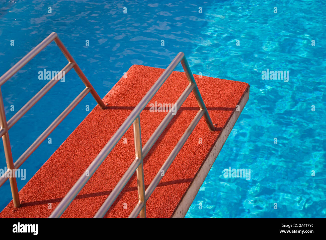 Red trampolino di una piscina diving torre con acqua blu Foto Stock