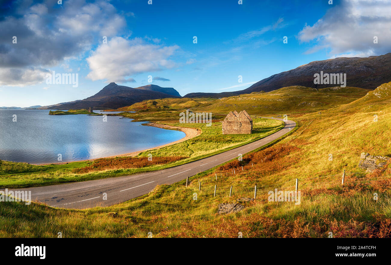 Autunno a Loch Assynt in Scozia con le rovine della casa calda e Ardvreck Castle in più a sinistra, i punti di riferimento sul NC500 scenic percorso di guida Foto Stock