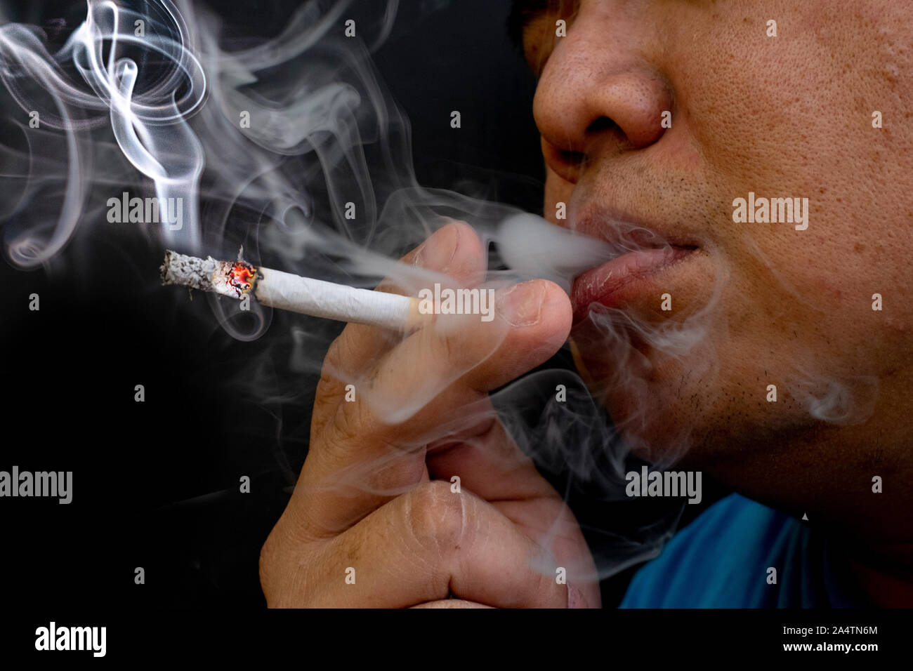 Uomo di fumare una sigaretta, immagine della sigaretta in mano con fumo Foto Stock