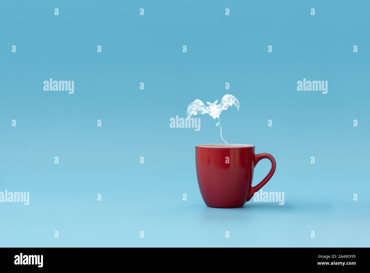 Vapore in forma bat battenti dalla tazza di caffè contro lo sfondo blu. Drink di mattina. Festa di Halloween concetto. Copia dello spazio. Foto Stock