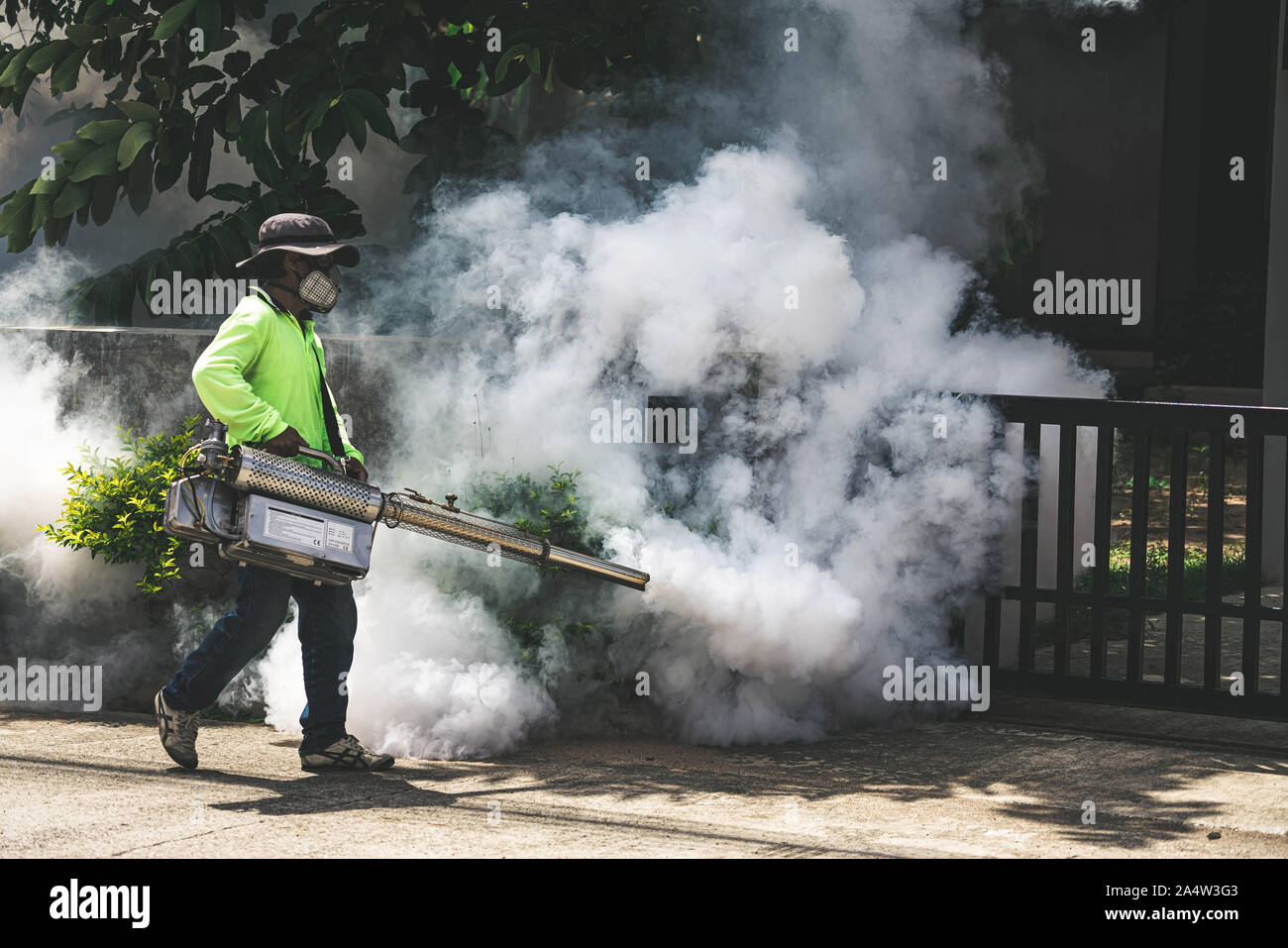 Uomo che utilizza fogger macchina a controllo da pericolose zanzare Foto Stock