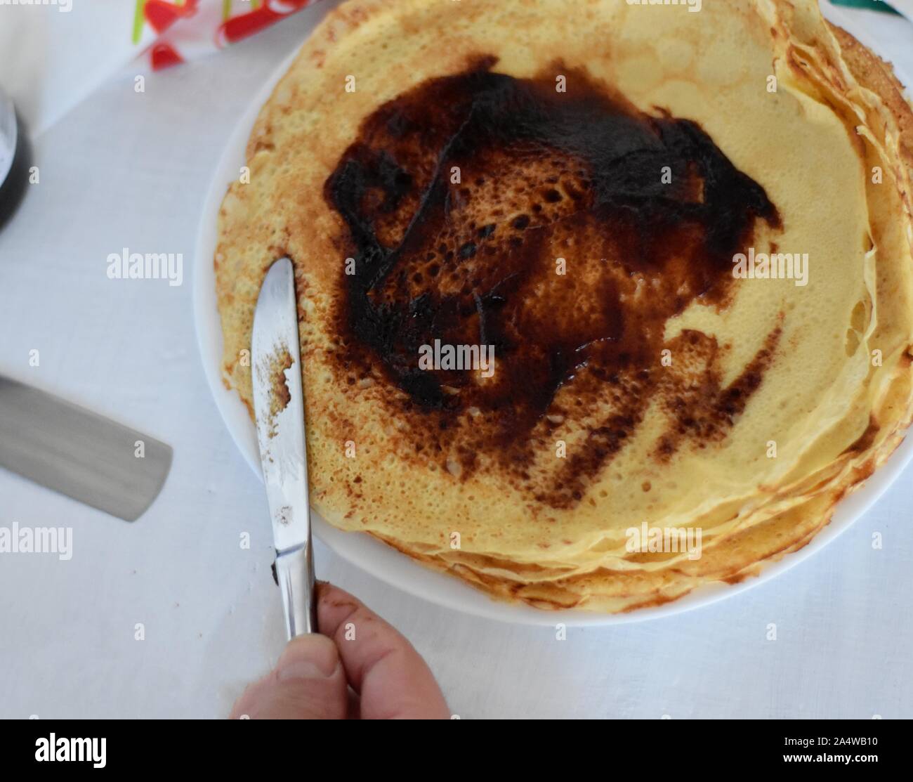 Diffusione di crema di cioccolato su thin pancake/ deliziosa crepes whit pasta cioccolato Foto Stock