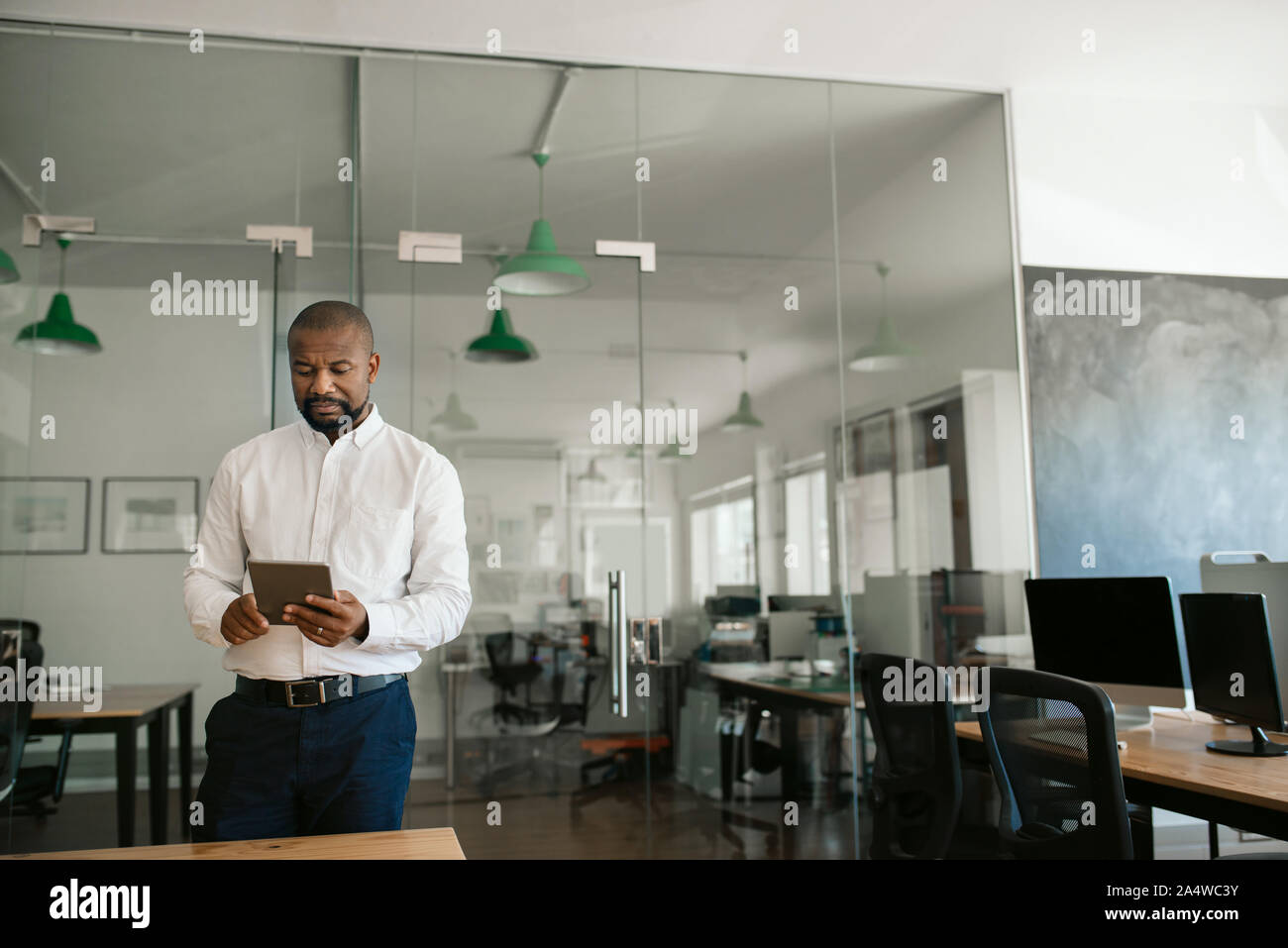 African American businessman lavorando su un tablet nel suo ufficio Foto Stock
