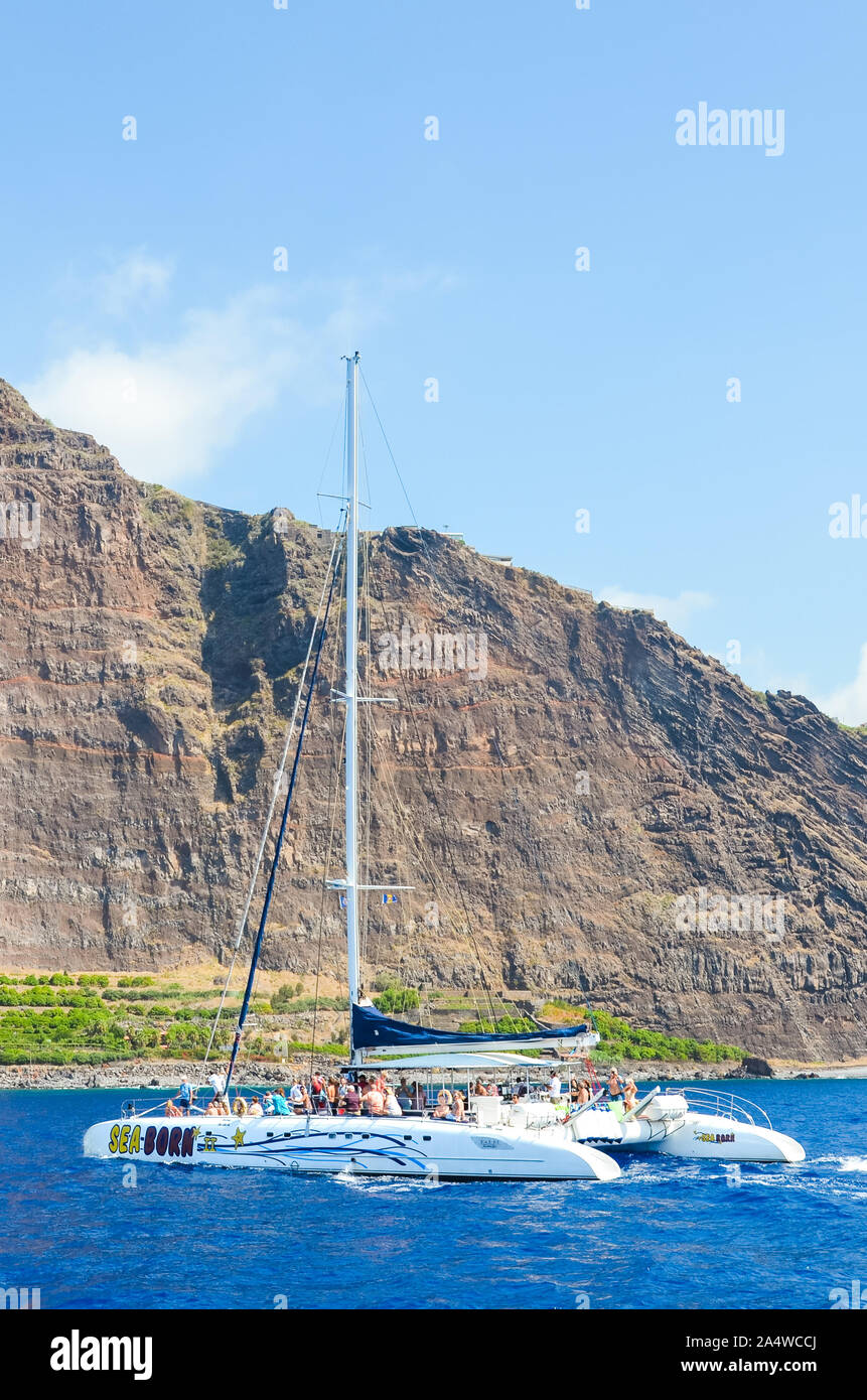 Madeira, Portogallo - Sep 10, 2019: tour in barca nelle acque dell'Oceano Atlantico. Ripida roccia su un isola portoghese in background. Avvistamento Balene, delfini viaggi. Crociera. Foto Stock