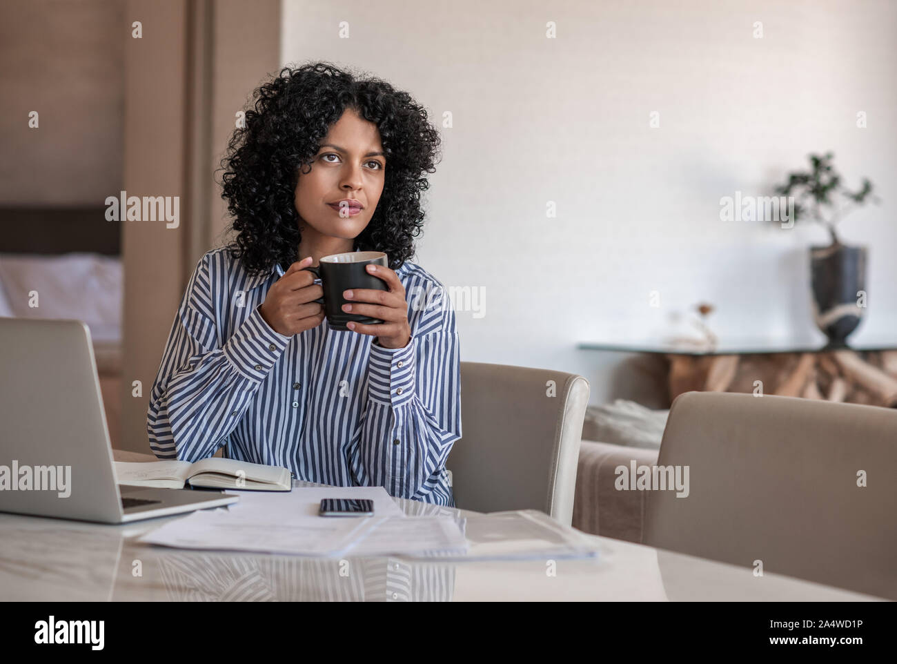 Imprenditore femmina di bere il caffè mentre si lavora da casa Foto Stock