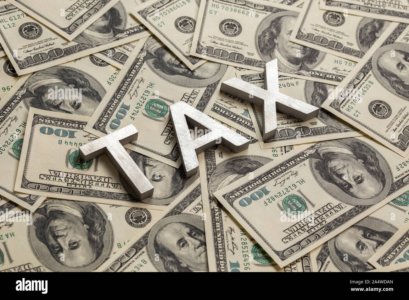 Le parole imposta prevista con alluminio di spessore lettere sulla US Dollar Bills background - con messa a fuoco selettiva e composizione diagonale. Foto Stock