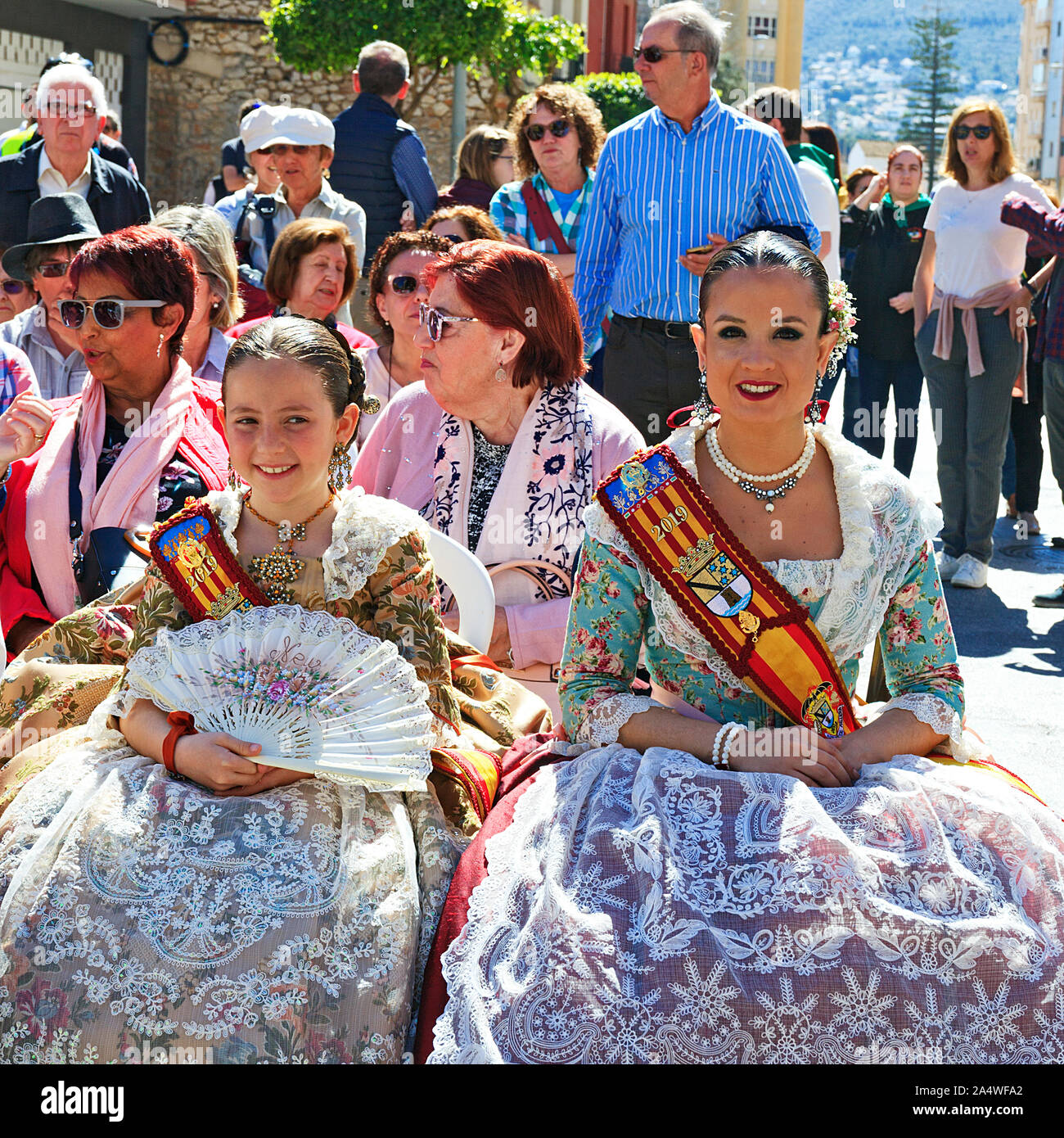 Falleras majors di Denia in costume tradizionale frequentando il concerto di strada 2019 Foto Stock