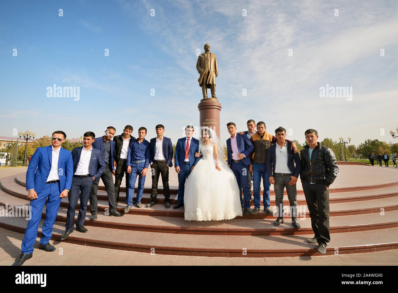 Una sessione di foto per il matrimonio di fronte alla statua del defunto capo Islam Karimov. Samarcanda, Uzbekistan Foto Stock