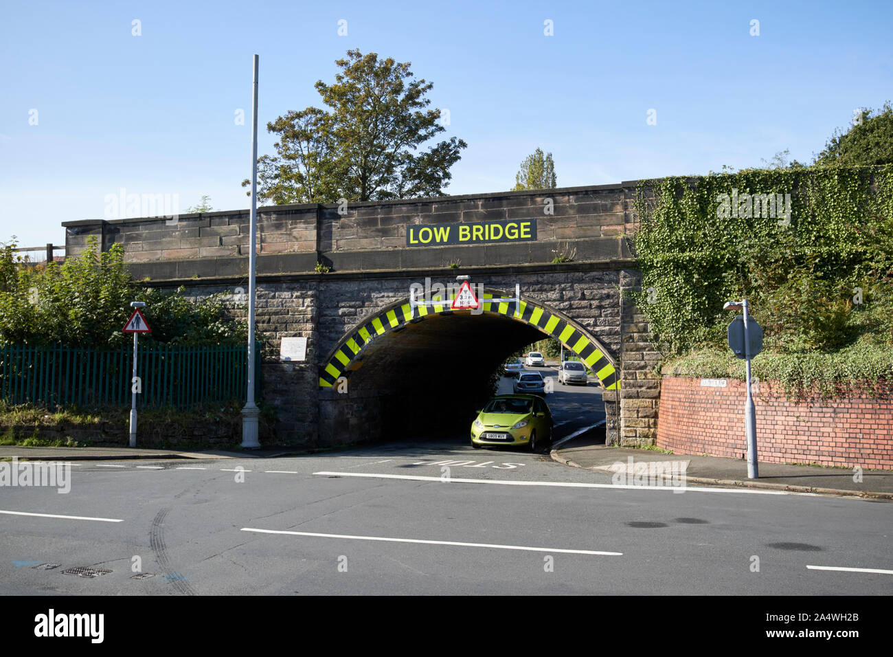 Auto passando sotto bassa ponte ferroviario ellens lane Port Sunlight England Regno Unito Foto Stock