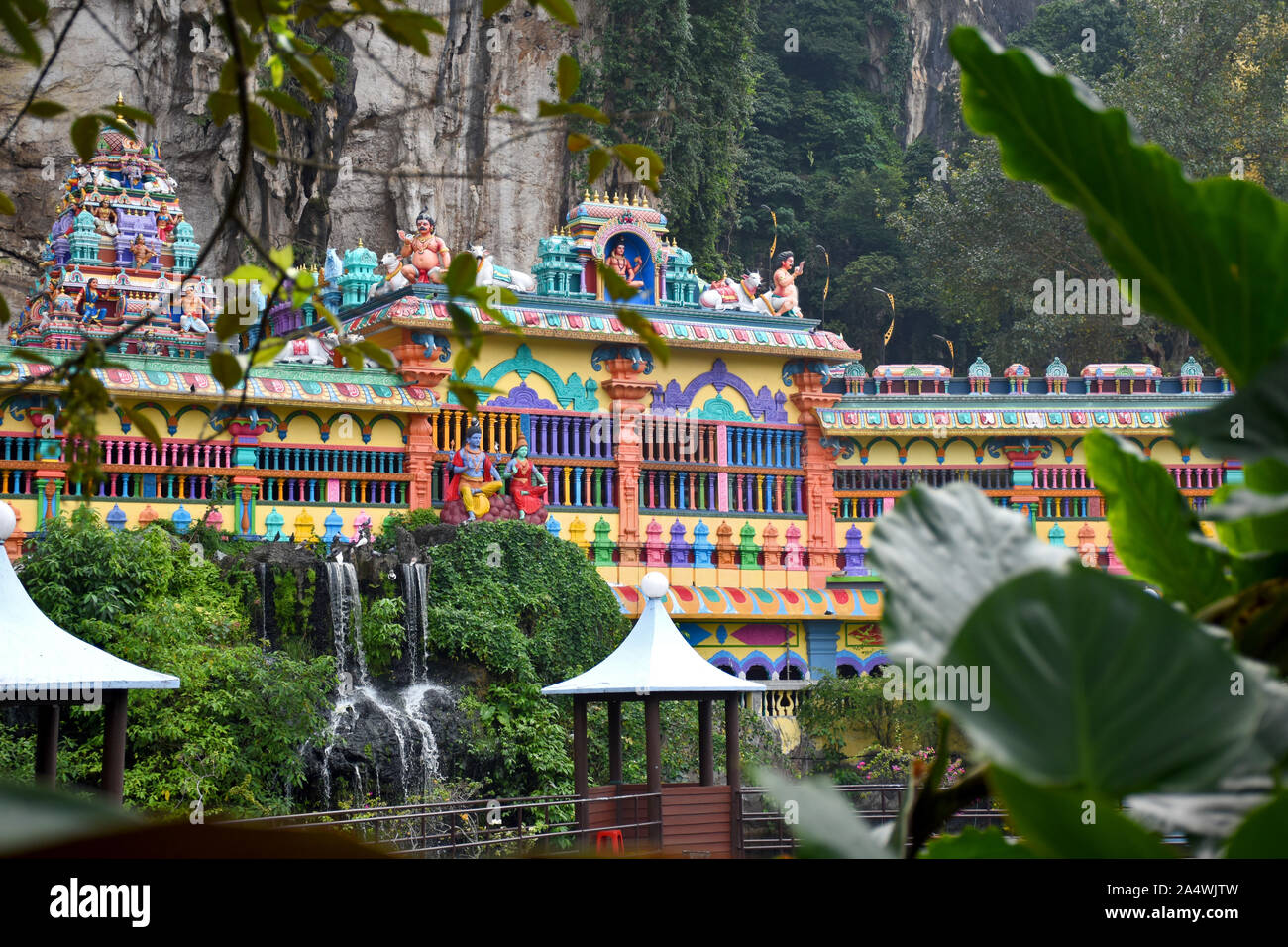 Gombak, Selangor, Malaysia 08.14.2019: un piccolo lago che circonda la colorata architettura dravidico grotte decorate Villa a Grotte Batu Foto Stock