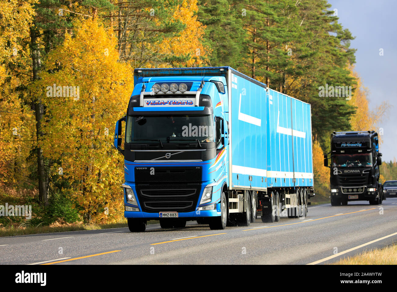 Blue Volvo FH autocarro pesante di Veka-Trans tira il rimorchio lungo la strada fiancheggiata da alberi in autunno colori. Salo, Finlandia. Ottobre 11, 2019. Foto Stock