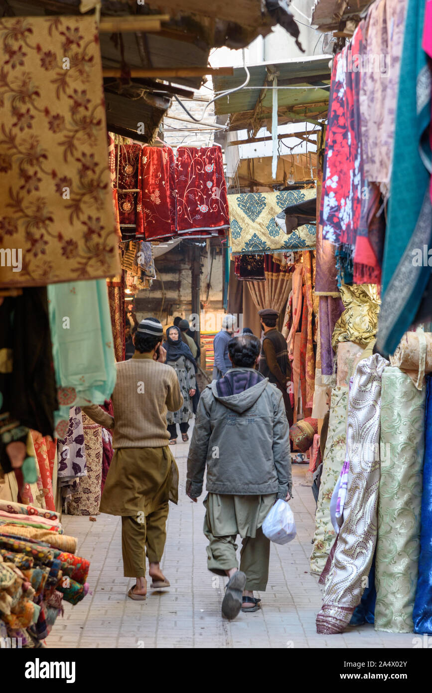 A Peshawar, Pakistan - Gennaio 1, 2015: vestiti appesi per un display nella strada stretta di Shaheen bazaar nella parte vecchia della città di Peshawar. Foto Stock