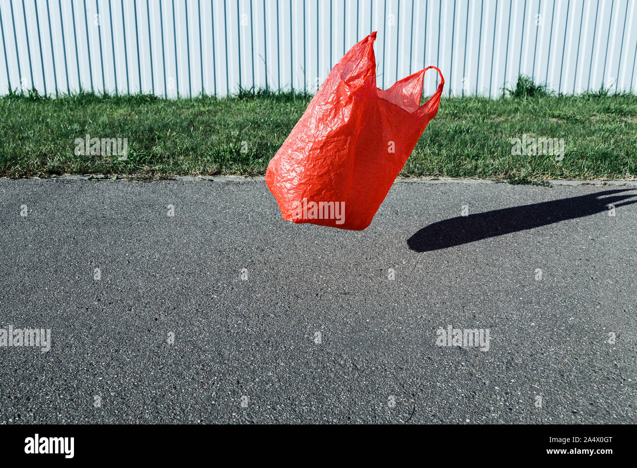 Concetto di inquinamento. Il sacchetto in plastica, volare nel vento in strada. Foto Stock