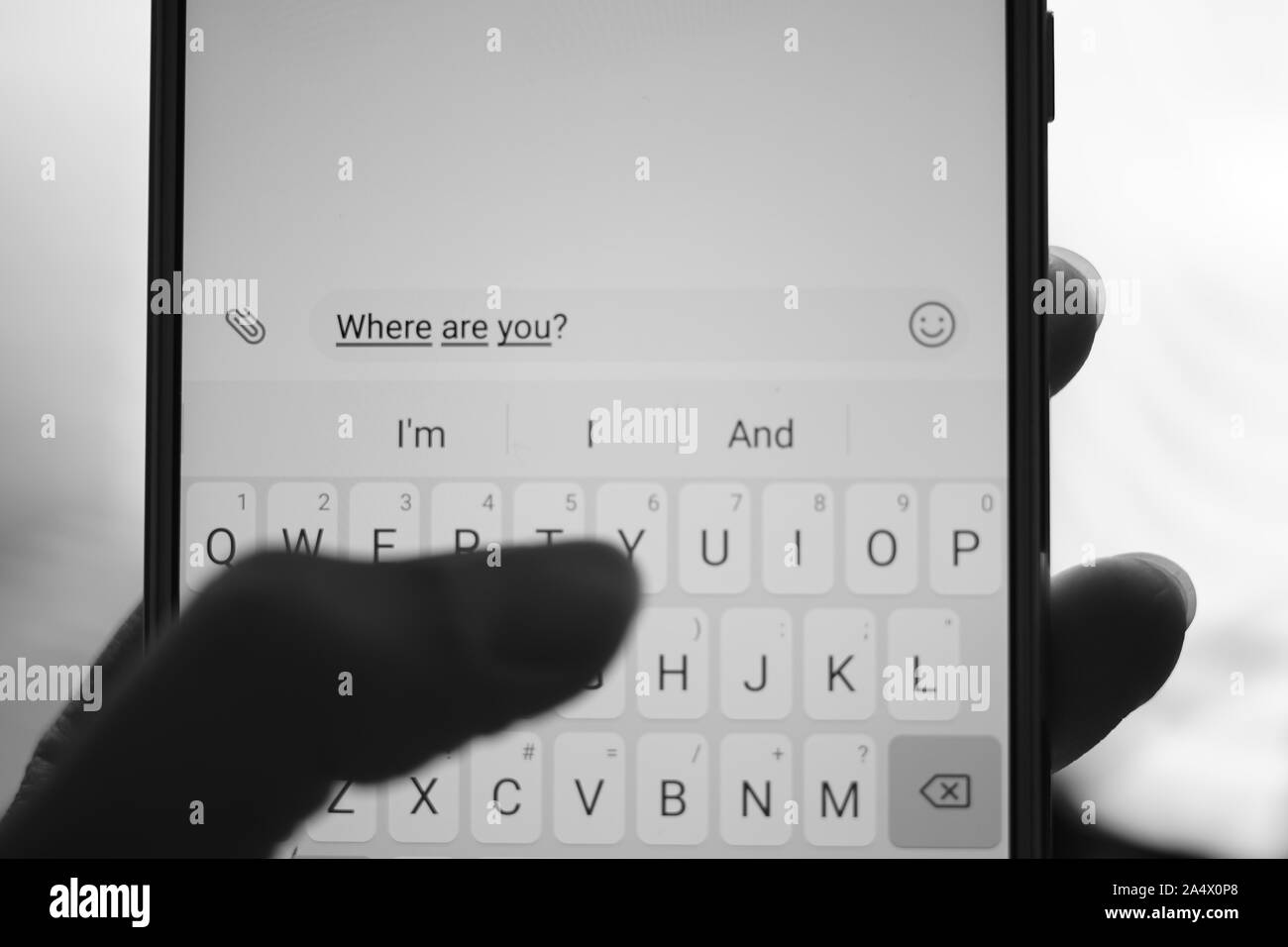 Mano umana la digitazione su smartphone bianco un messaggio dove sei. BW foto. Foto Stock