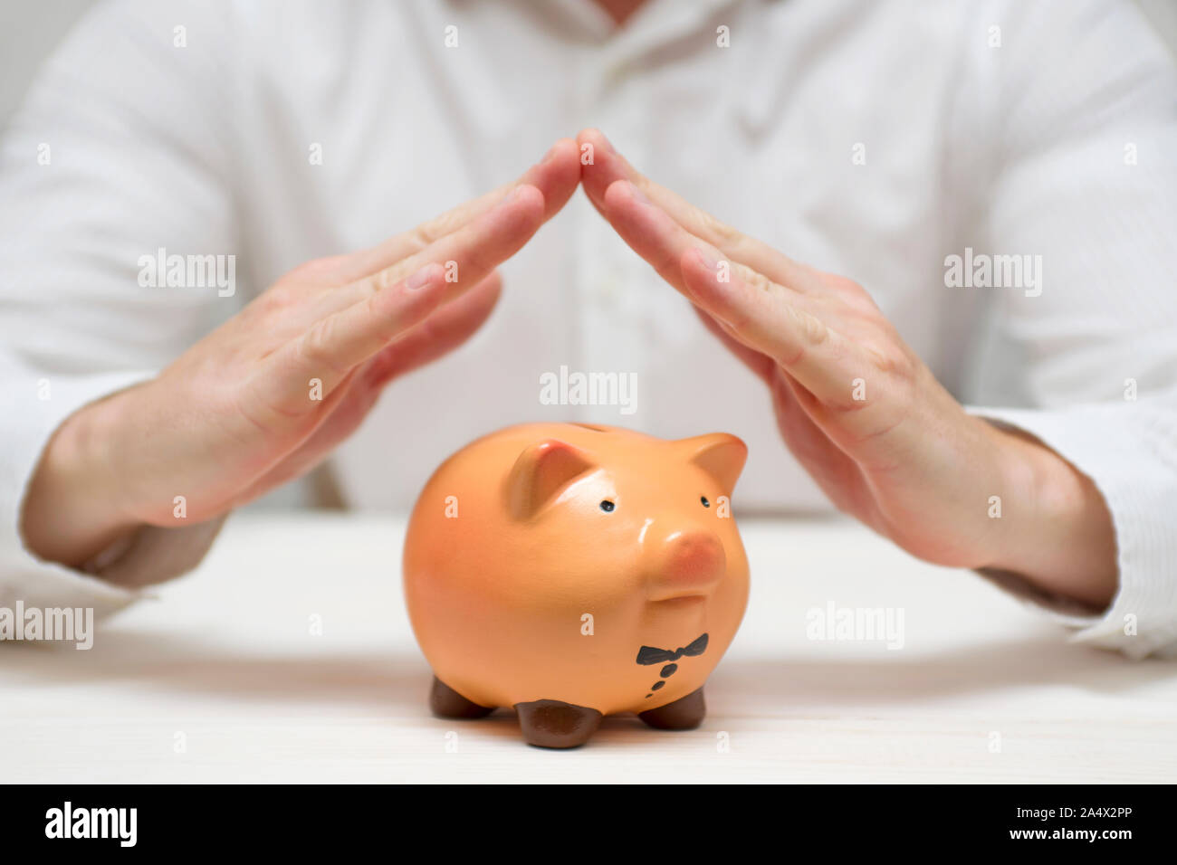 Proteggere le mani il salvadanaio. Concetto di assicurazione finanza, protezione, sicuro investimento bancario o con le mani su un salvadanaio. Foto Stock