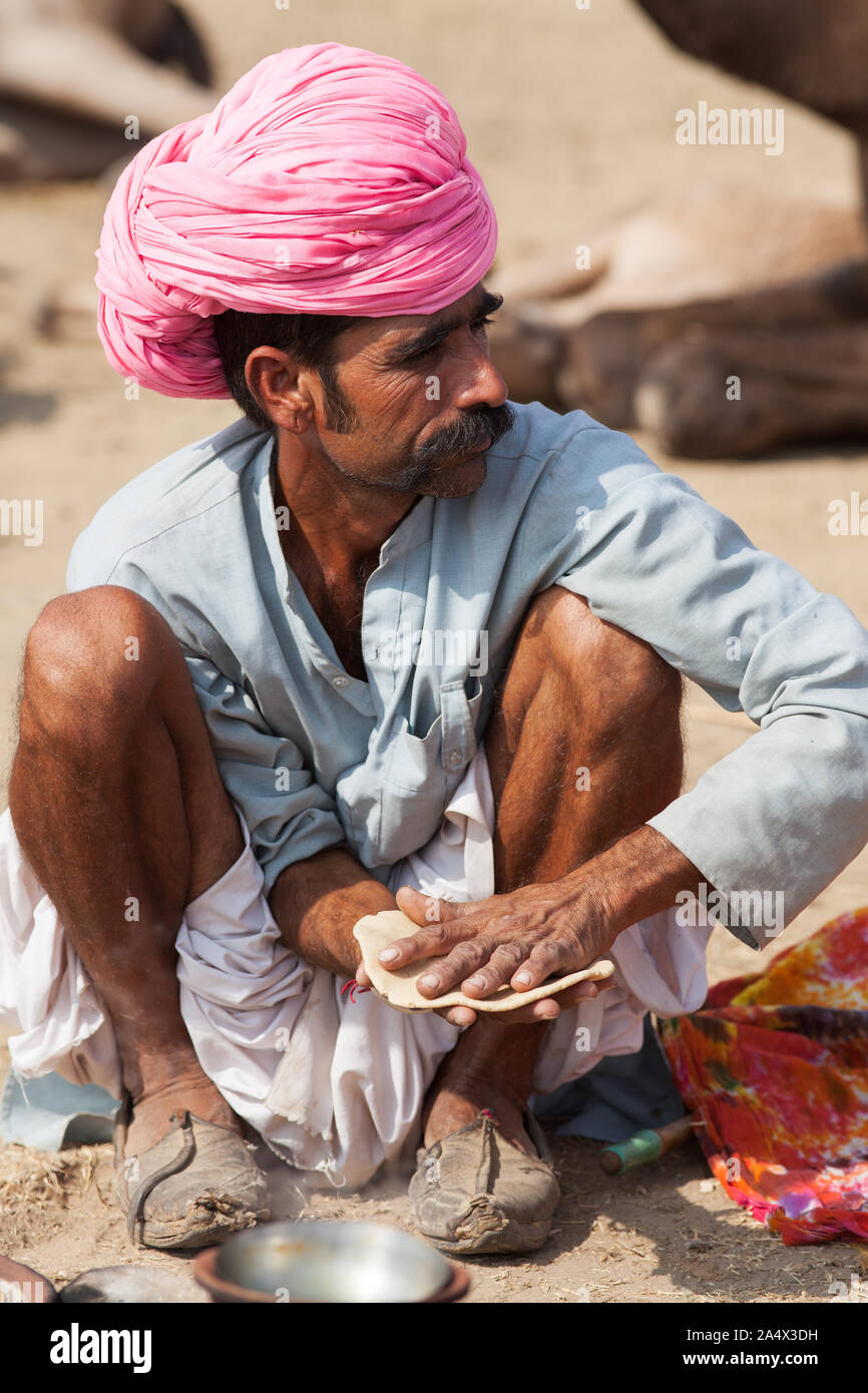 Uomo di Rajasthani rendendo chapati pane a Pushkar Camel Fair, Rajasthan, India Foto Stock