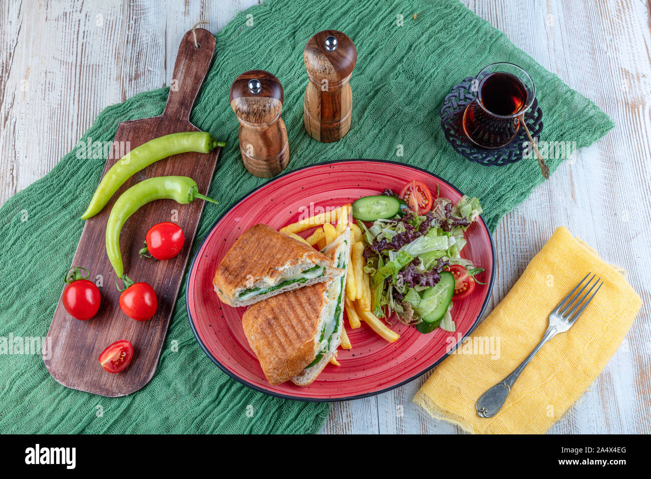 Grigliato pressato e toast con formaggio affumicato, pomodori e lattuga servita su sfondo di legno. Foto Stock