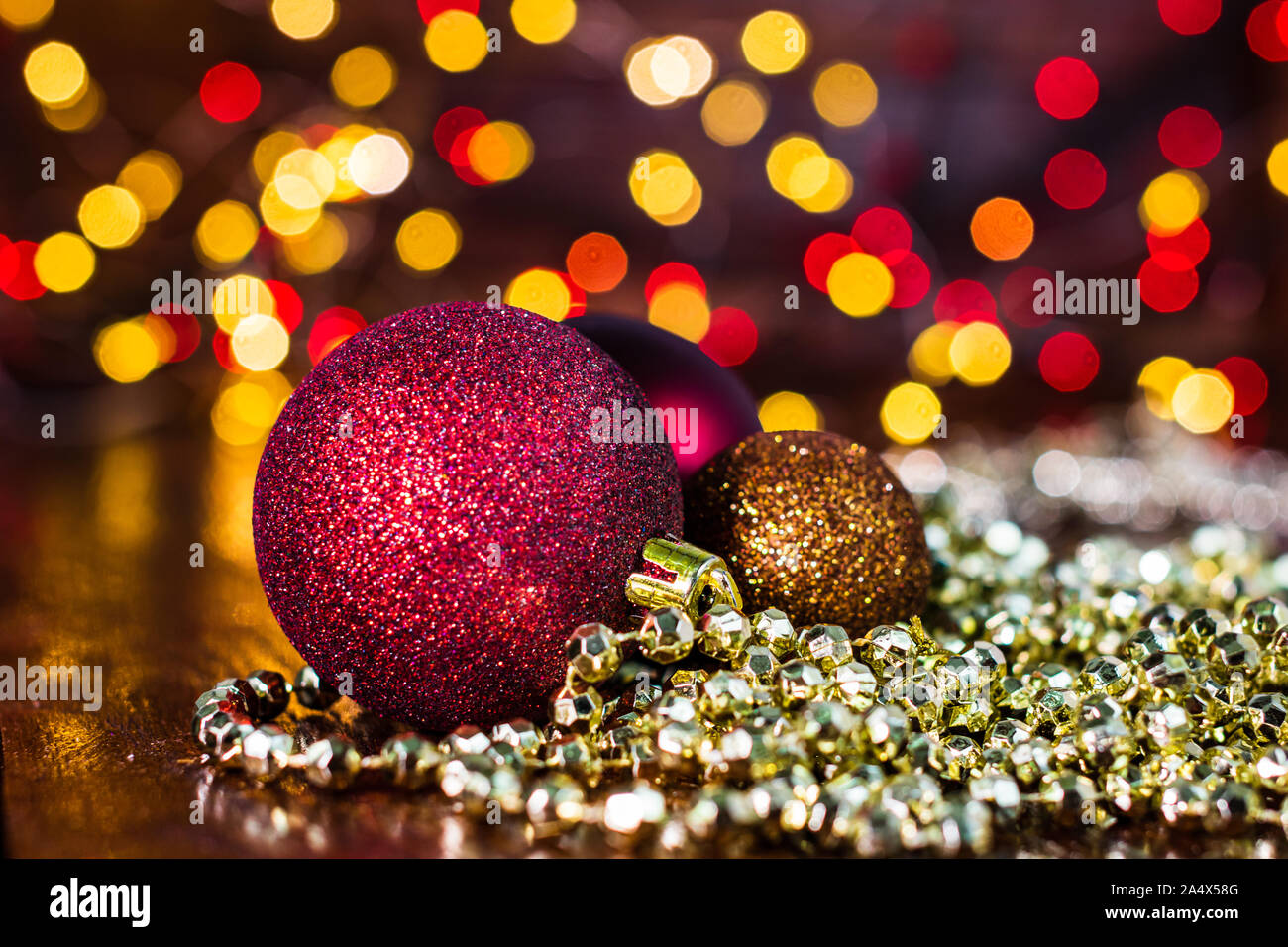 Le decorazioni di Natale contro sfondo sfocato e fuori fuoco luci. Close up di glittery palle di Natale Foto Stock