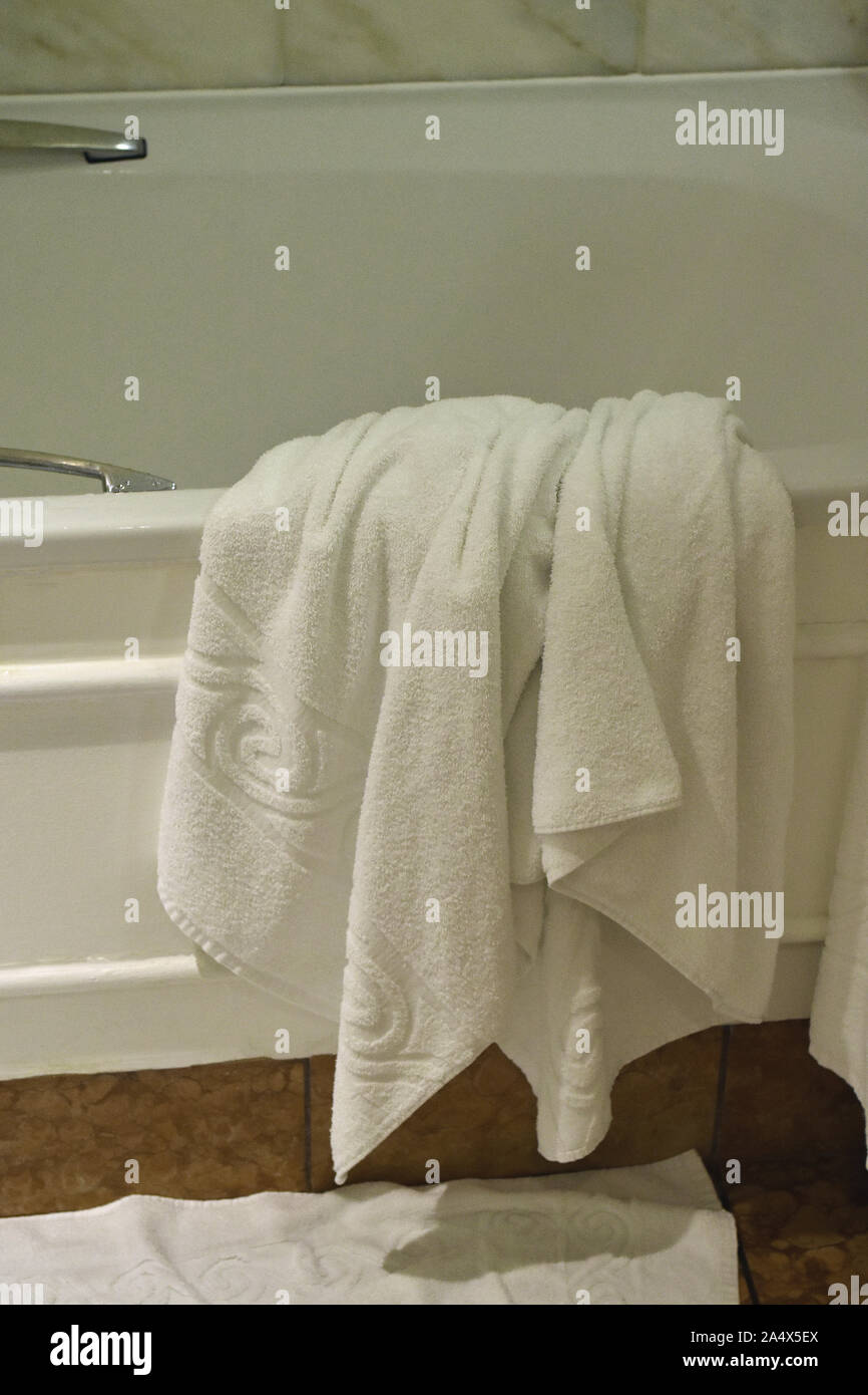 Hotel Bianco asciugamano stile scartati su vasca da bagno Foto Stock