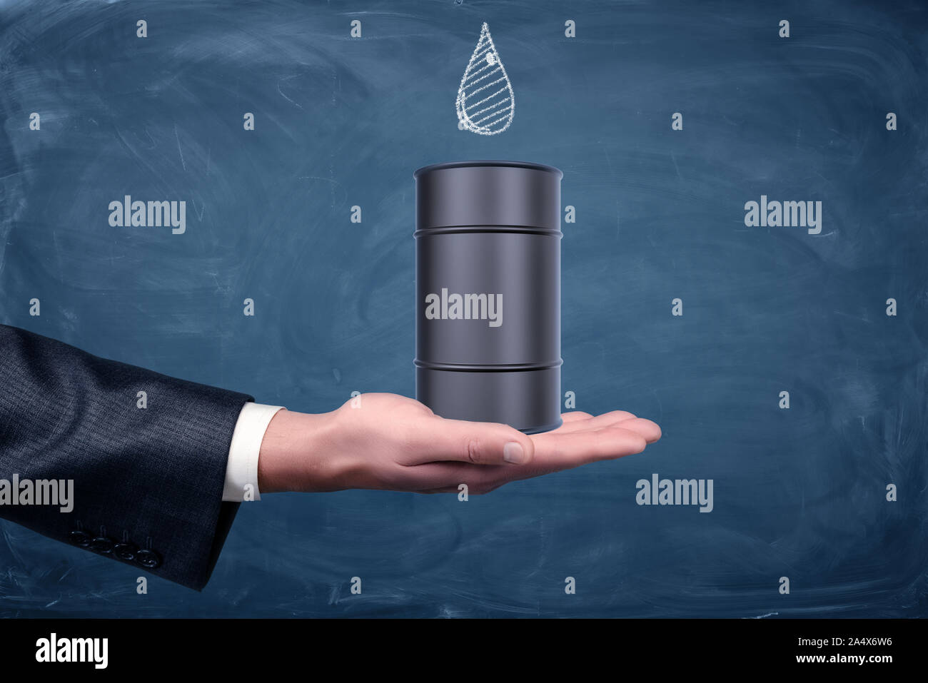 Un imprenditore il lato rivolto verso l'alto e un nero piccolo barile di petrolio in piedi su di esso con una goccia disegnata sulla lavagna. Foto Stock
