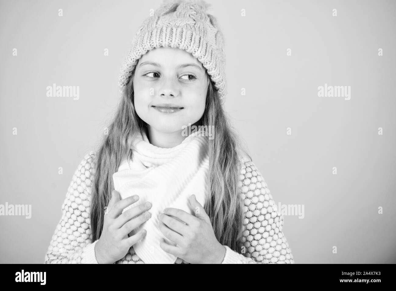 Riscaldare gli accessori che vi terrà accogliente d'inverno. Bambino capelli lunghi Caldo cappello di lana godetevi la calda e morbidezza. Kid ragazza indossare caldo a maglia hat rilassante sfondo rosa. Foto Stock