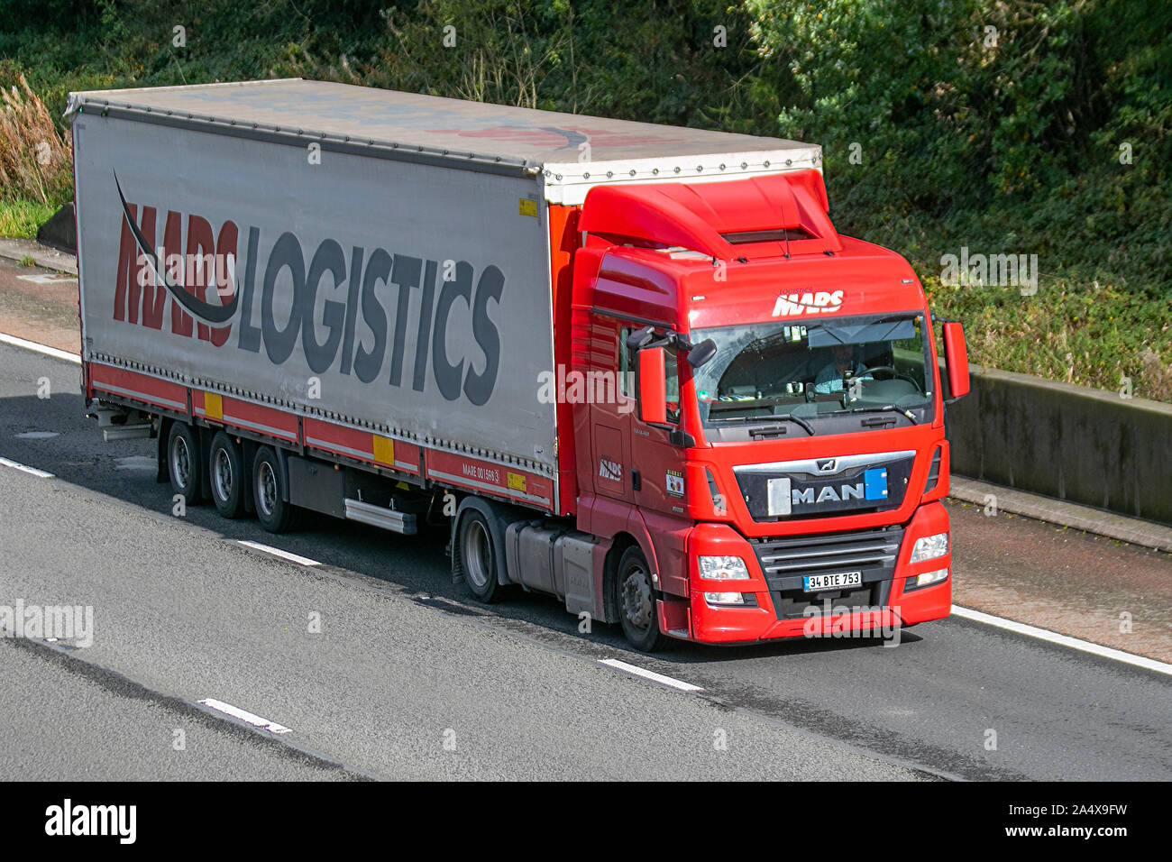 Rosso Marte la logistica del trasporto merci su strada; autostrada pesante di merci alla rinfusa camion di consegna trasporti, autocarro, trasporto, carrello, speciali cargo, uomo veicolo, consegna, trasporti, industria, merci sulla M6 a Lancaster, Foto Stock