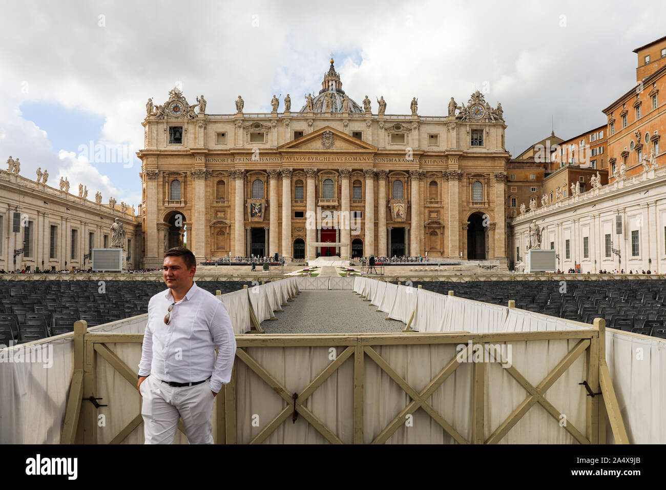 Turismo a maschio in posa per fotocamera in Piazza San Pietro con la Basilica di San Pietro sullo sfondo nello Stato della Città del Vaticano Foto Stock