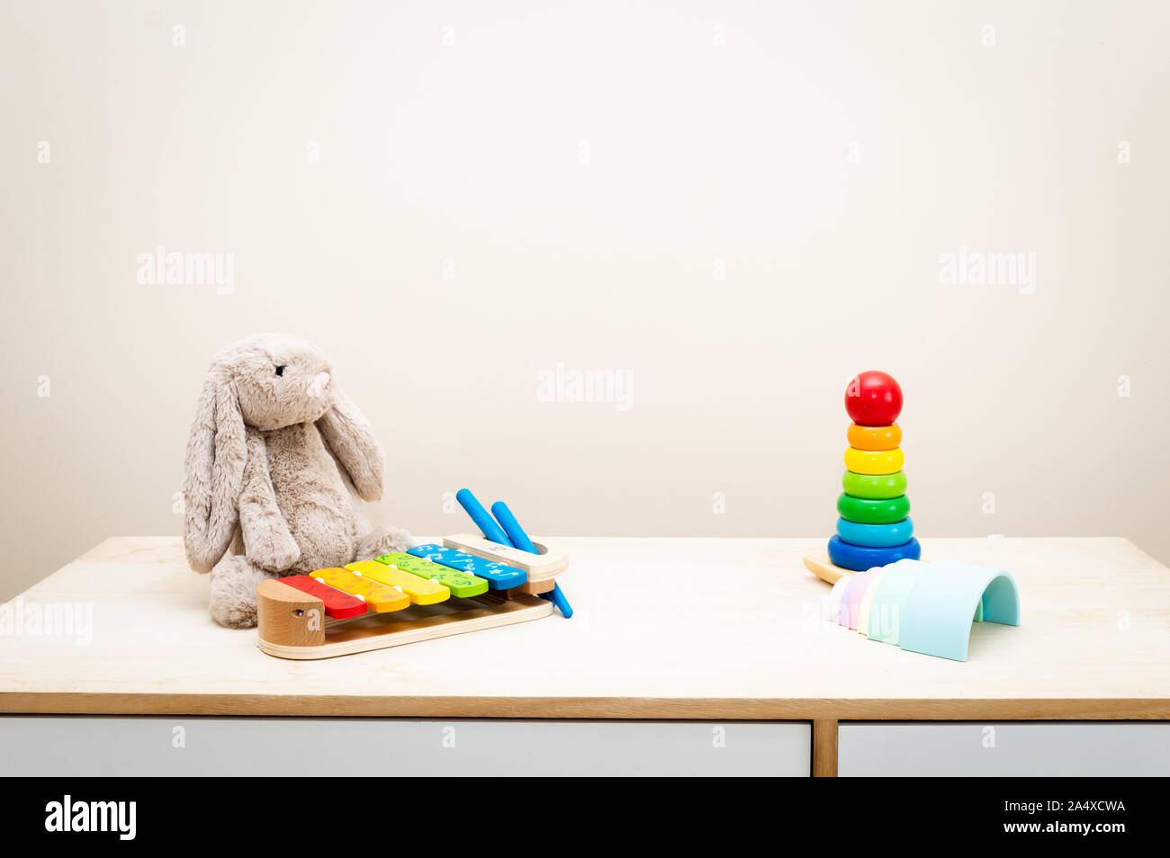 Sfondo colorato e i giocattoli dei bambini contro la parete Giocattoli su tavola di legno con copia spazio per il testo Foto Stock