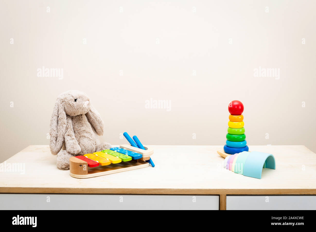 Sfondo colorato e i giocattoli dei bambini contro la parete Giocattoli su tavola di legno con copia spazio per il testo Foto Stock