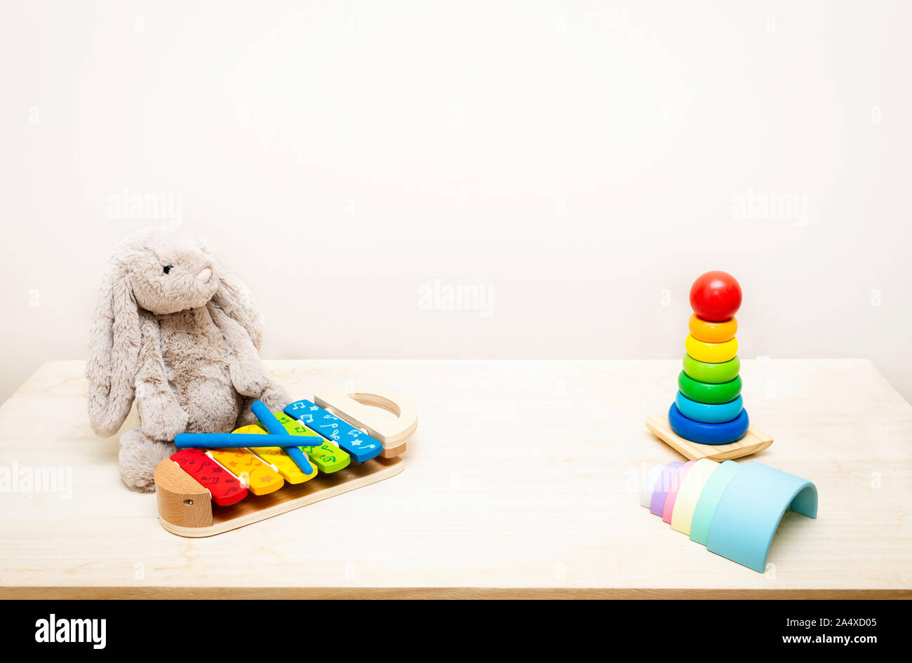 Sfondo colorato e i giocattoli dei bambini contro la parete Giocattoli su tavola di legno con copia spazio per il testo Foto Stock