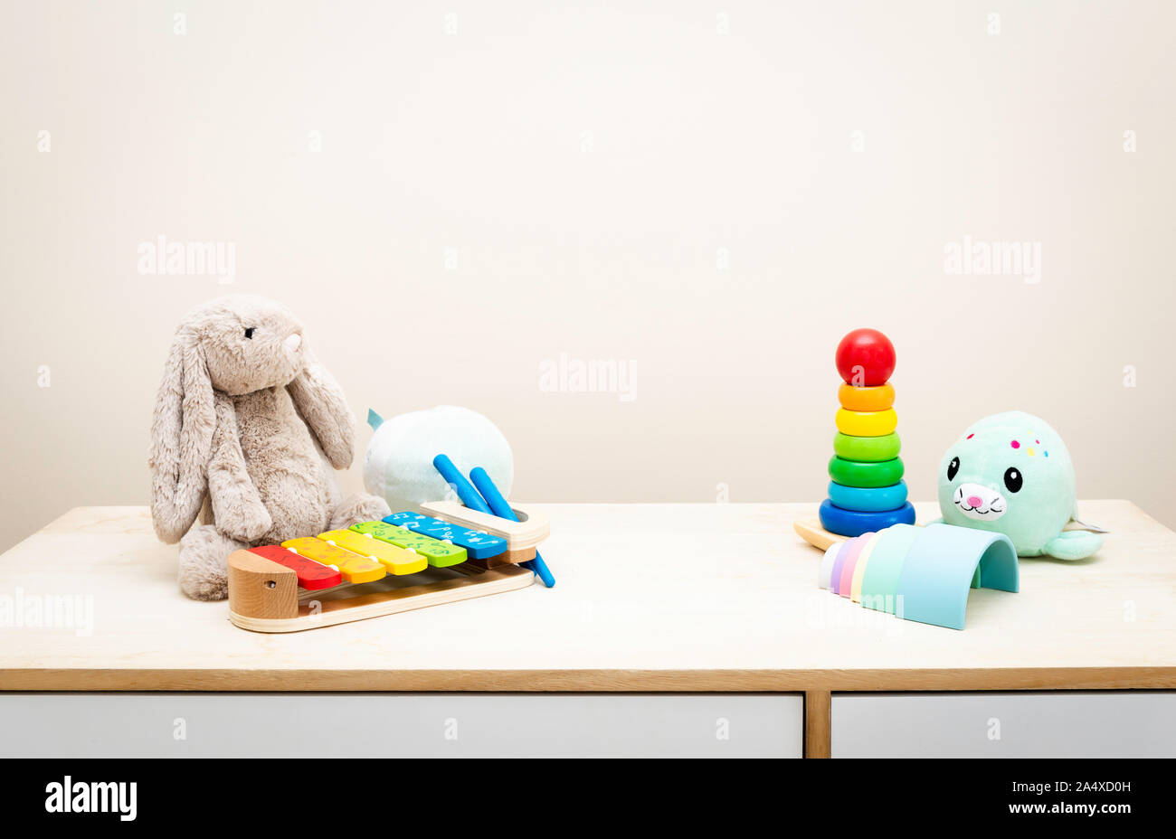 Sfondo colorato e i giocattoli dei bambini contro la parete Giocattoli su tavola di legno con copia spazio per il testo Foto Stock