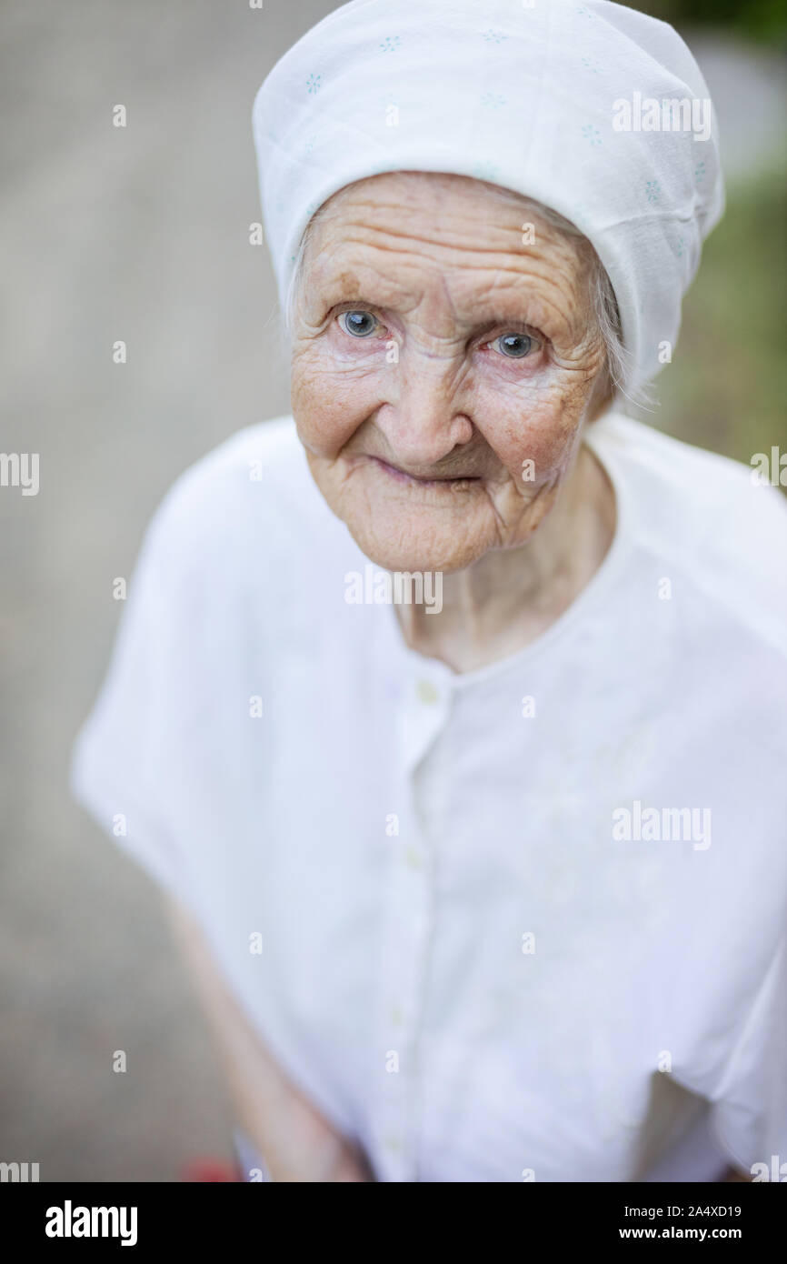 Ritratto di sorridente donna senior all'esterno guardando in alto Foto Stock