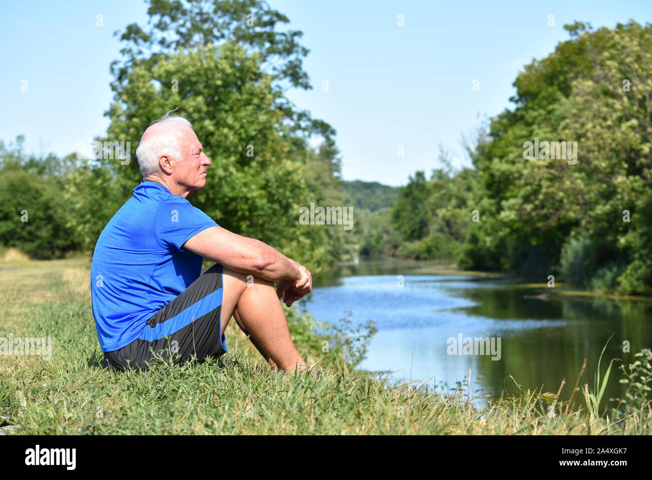 Athletic senior maschili Seduta Seduta dal fiume Foto Stock