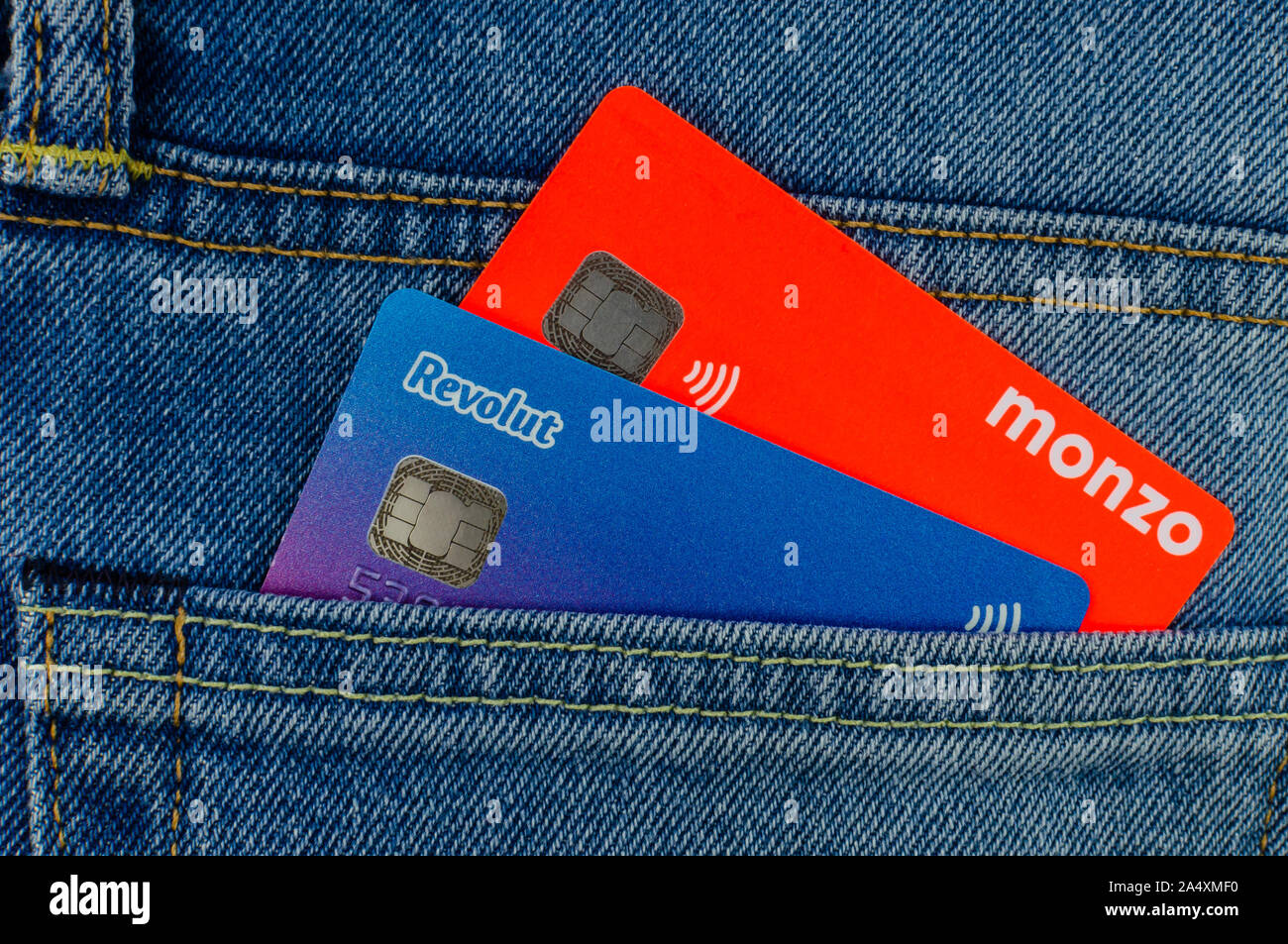 Monzo e Revolut carte bancarie inceppato dalla stessa tasca dei jeans. Concetto per un concorso in pinna tech market. Appartamento Foto laici. Foto Stock