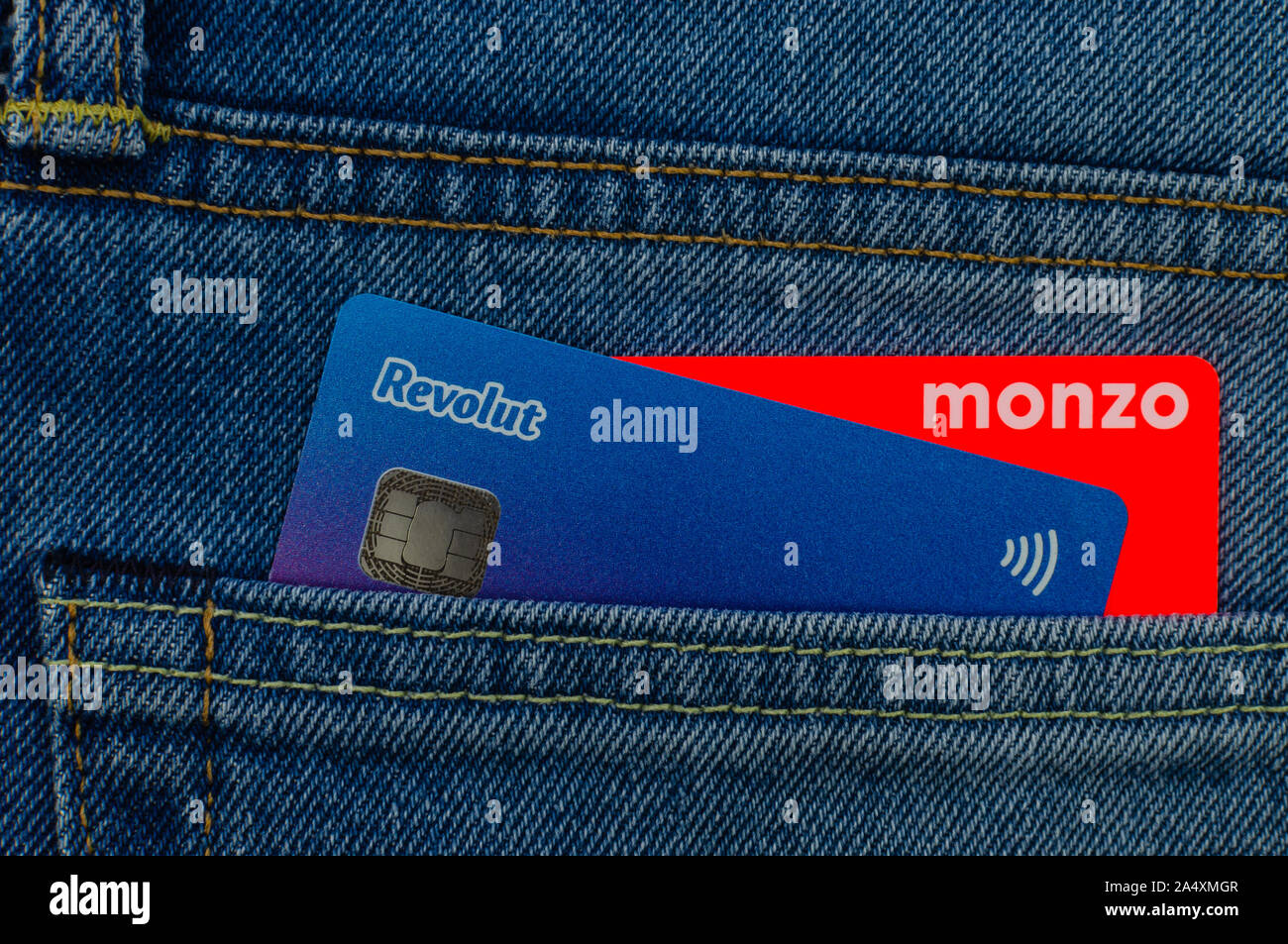 Monzo e Revolut carte bancarie inceppato dalla stessa tasca dei jeans. Concetto per un concorso in pinna tech market. Appartamento Foto laici. Foto Stock